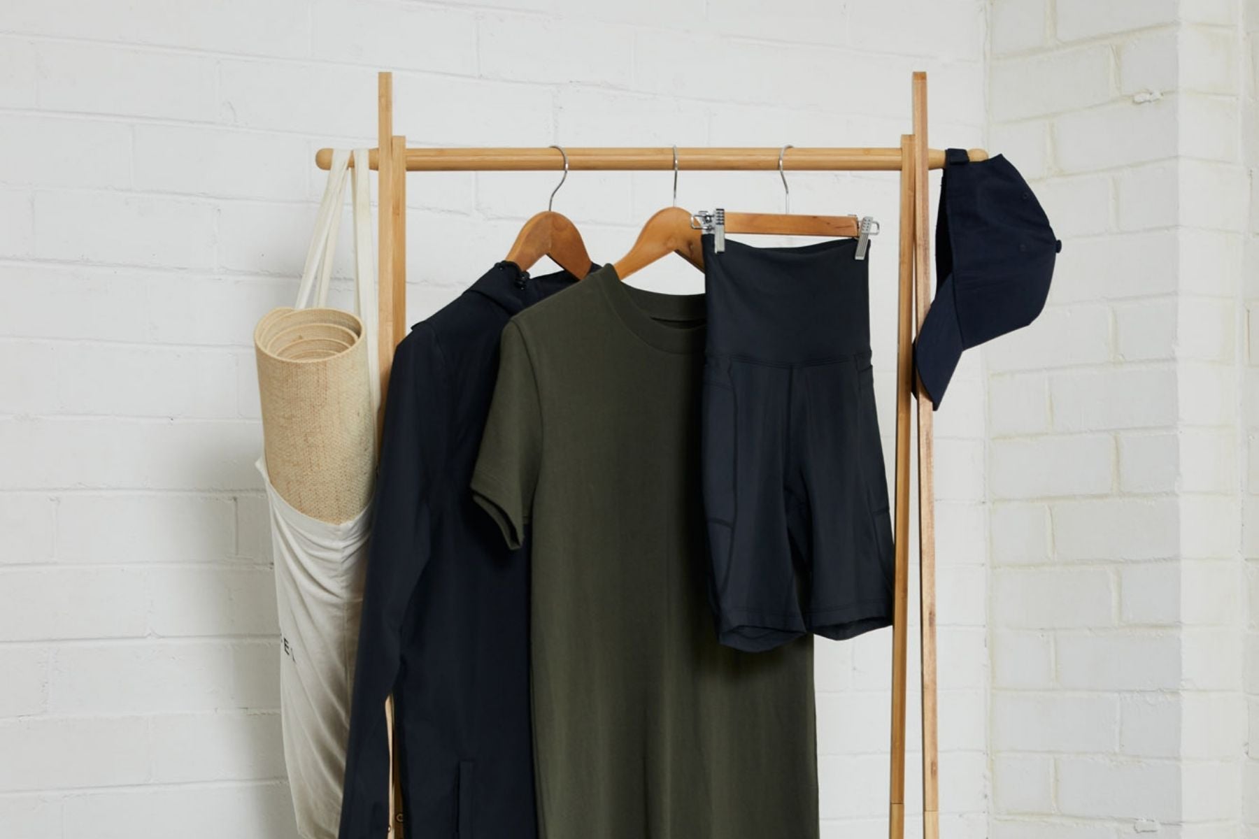 Neutral clothing hanging on a rack against a white background