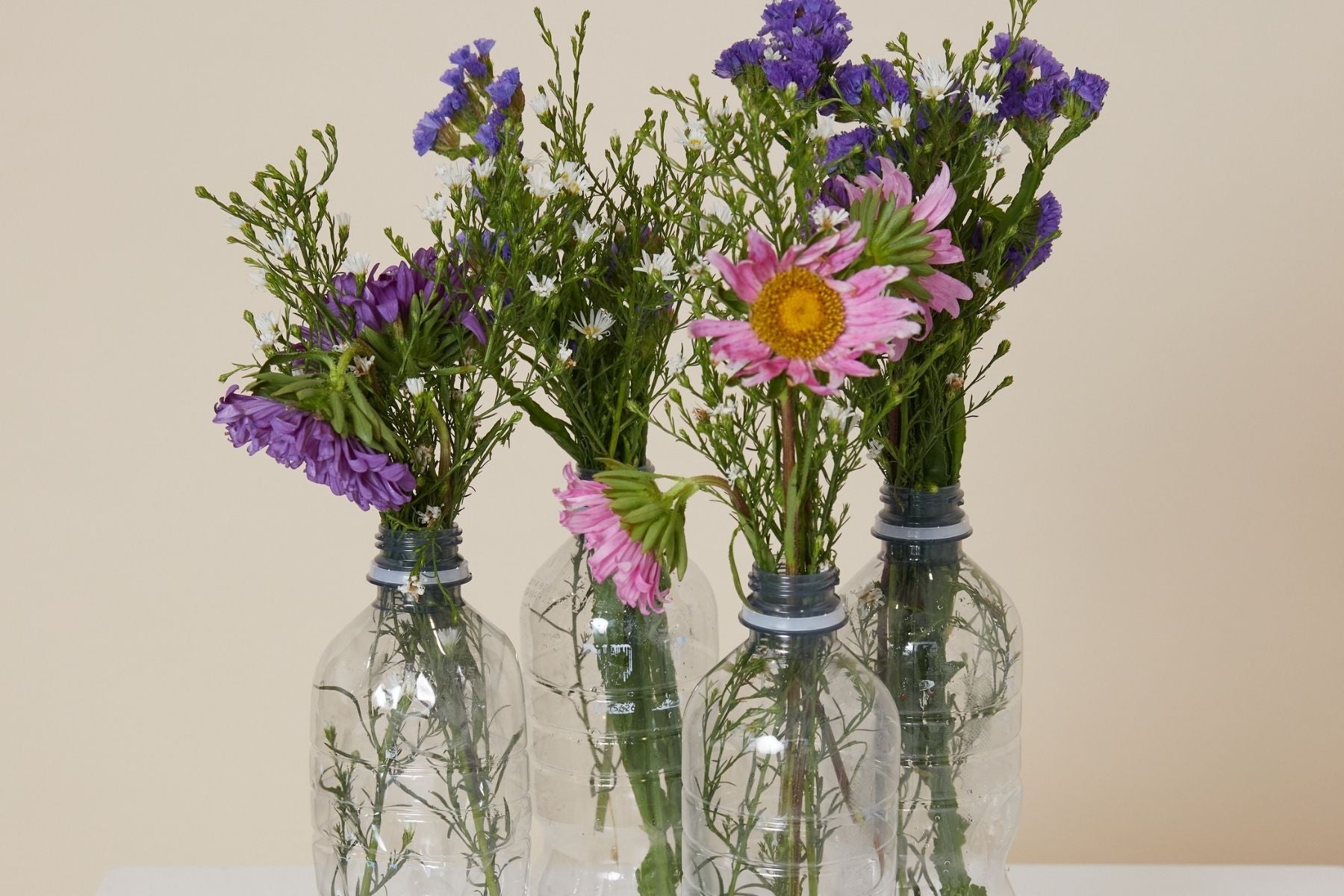 Post consumer bottles with flowers in them