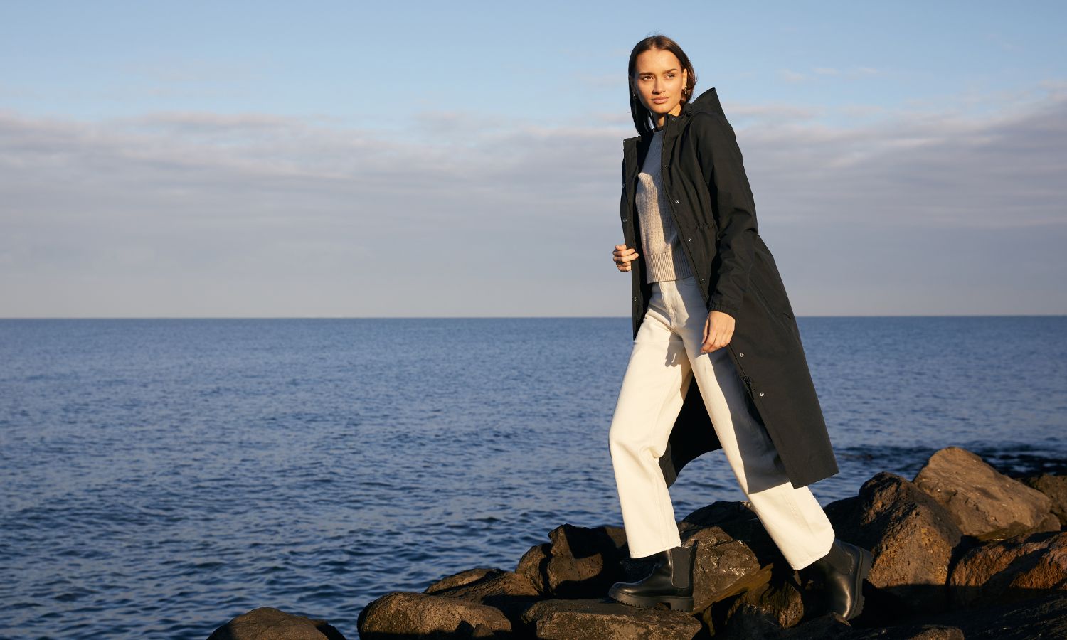 Model wearing the Overland Jacket in Black beside the coast